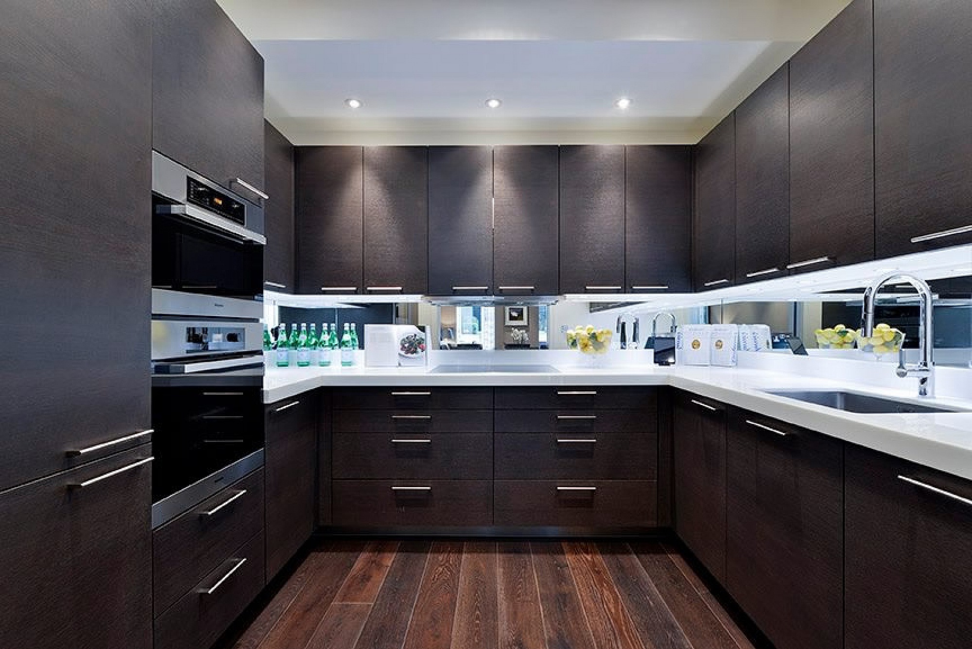 Charcoal Oak Kitchen with Silestone Blanco Zeus Extreme White work surfaces and upstands, large pocket doors, horizontal grain charcoal oak units by Rational