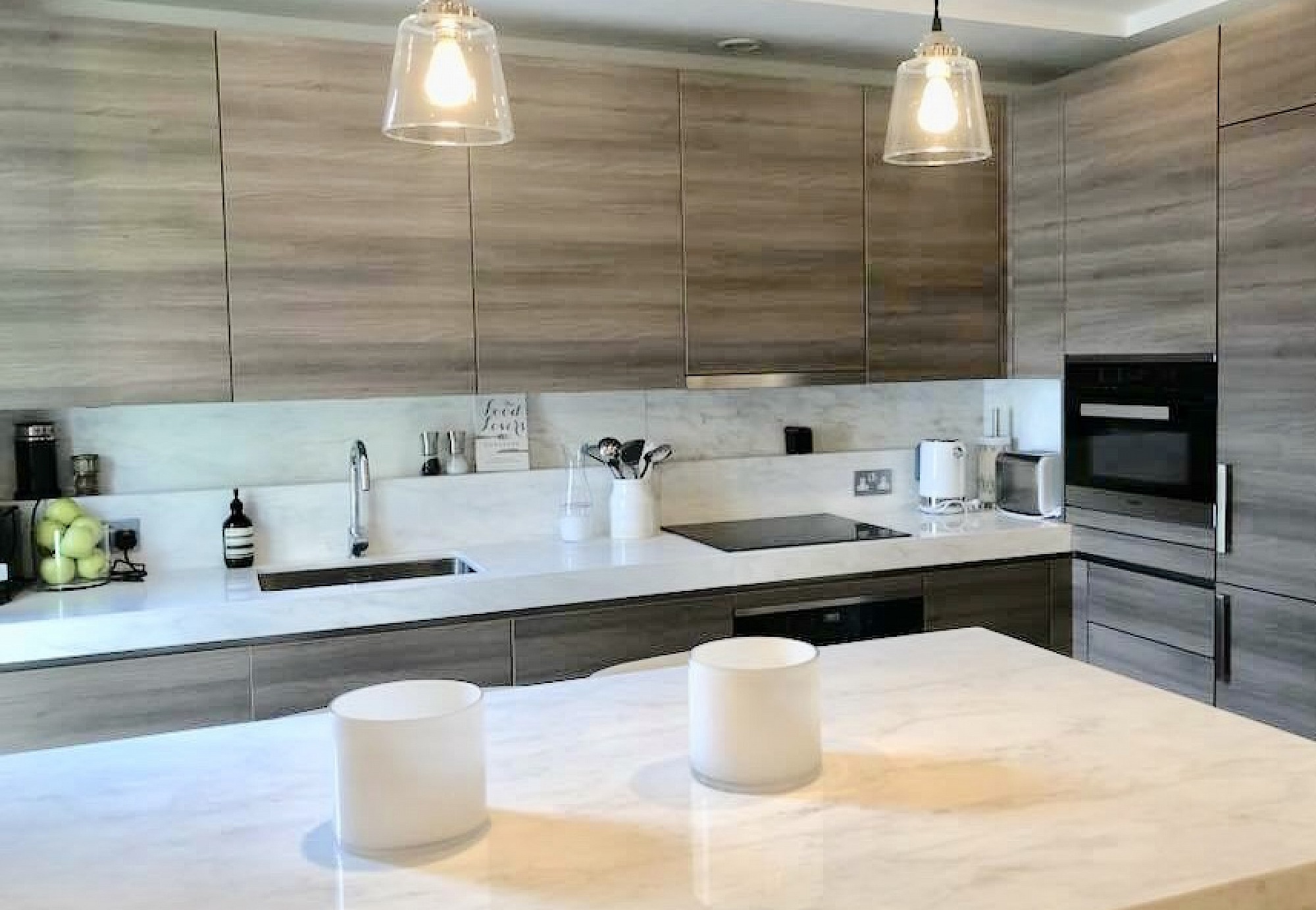 Exclusive designer kitchen marble surfaces South Kensington, with Miele appliances handle-less design in a horizontal veneer cabinets