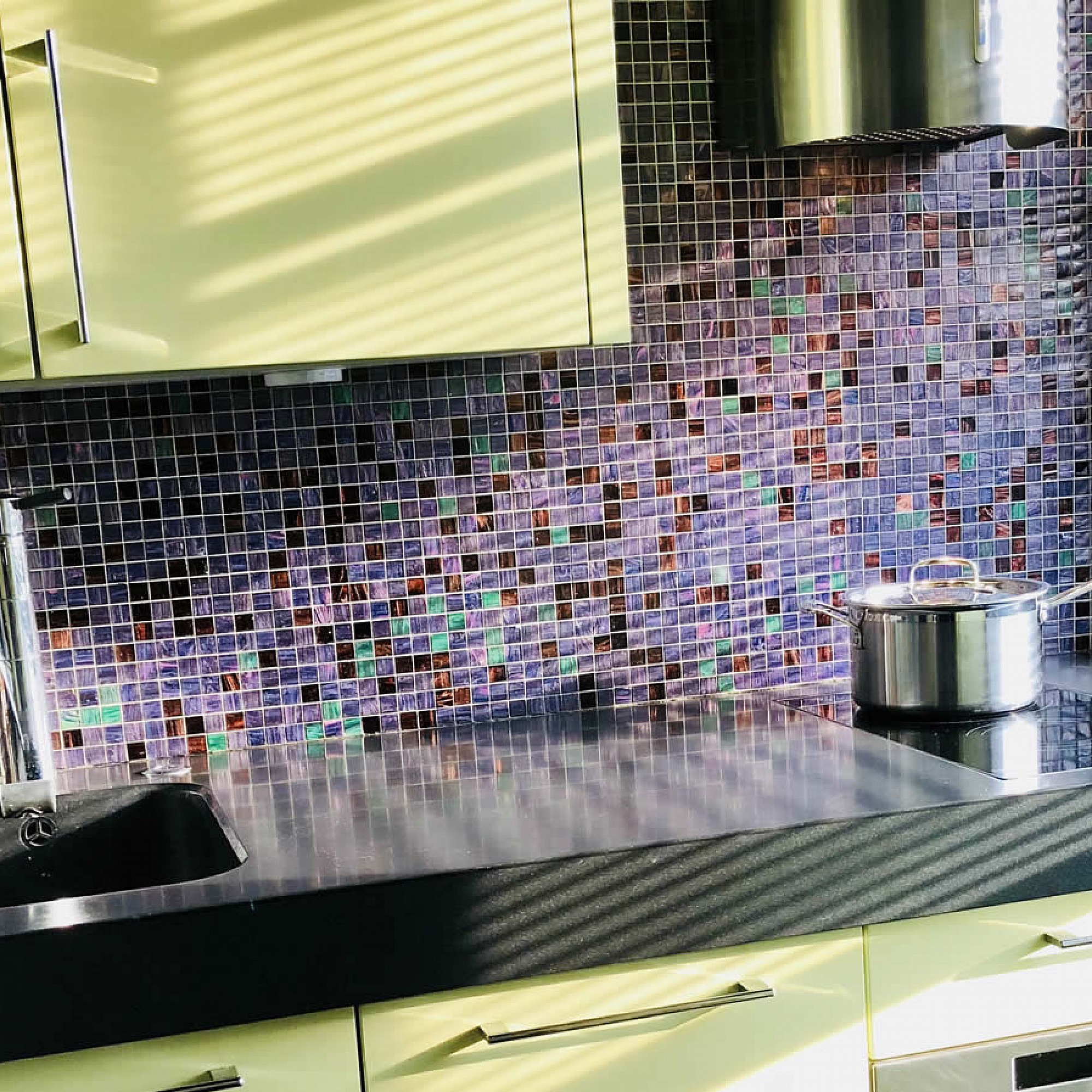 A small bespoke kitchen in Chelsea with Pistachio in high gloss Lacquer integrated Corian sink and Rational furniture, emerald and dark amber Bisazza mosaics